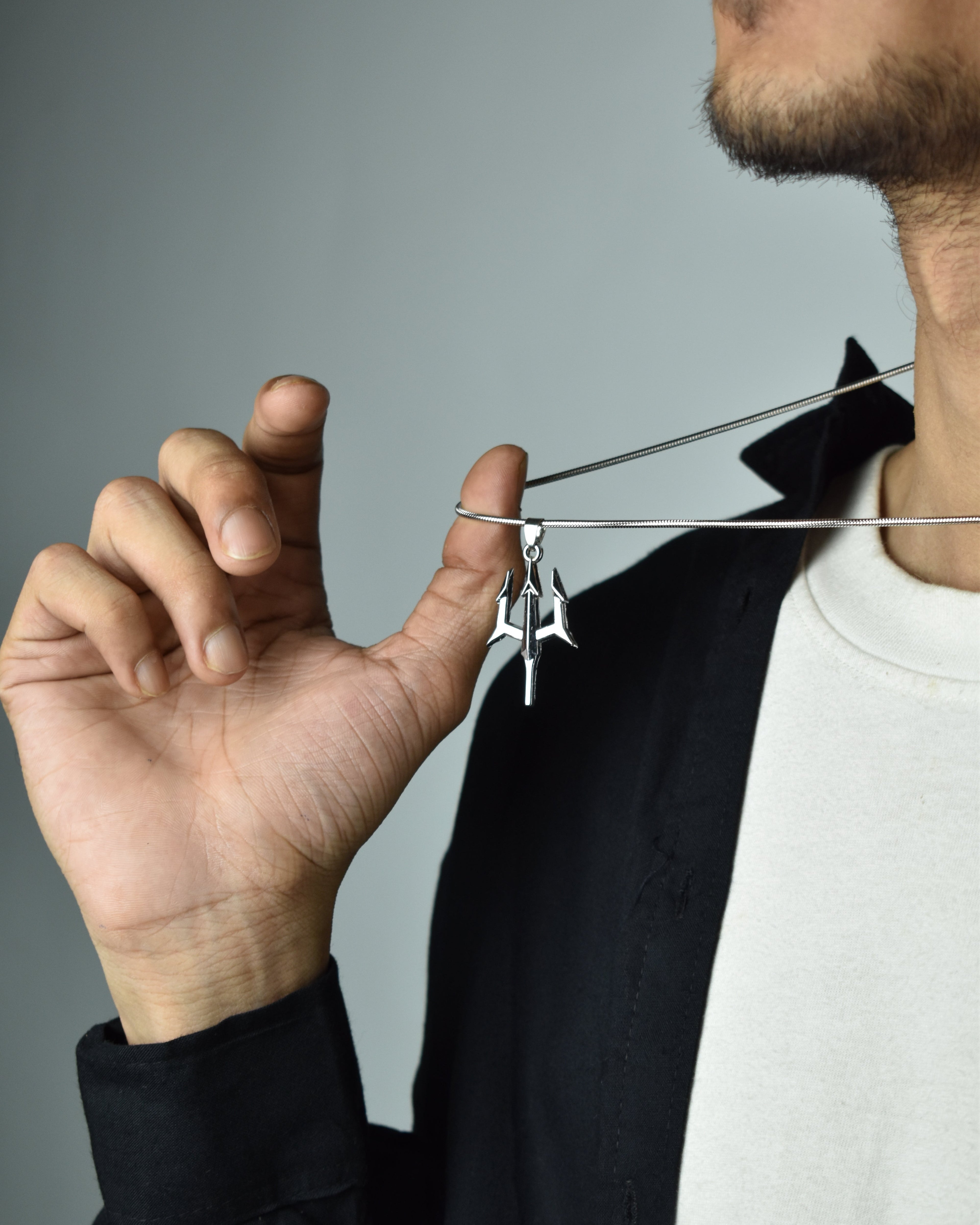 Trident pendant and a chain in a men's hand