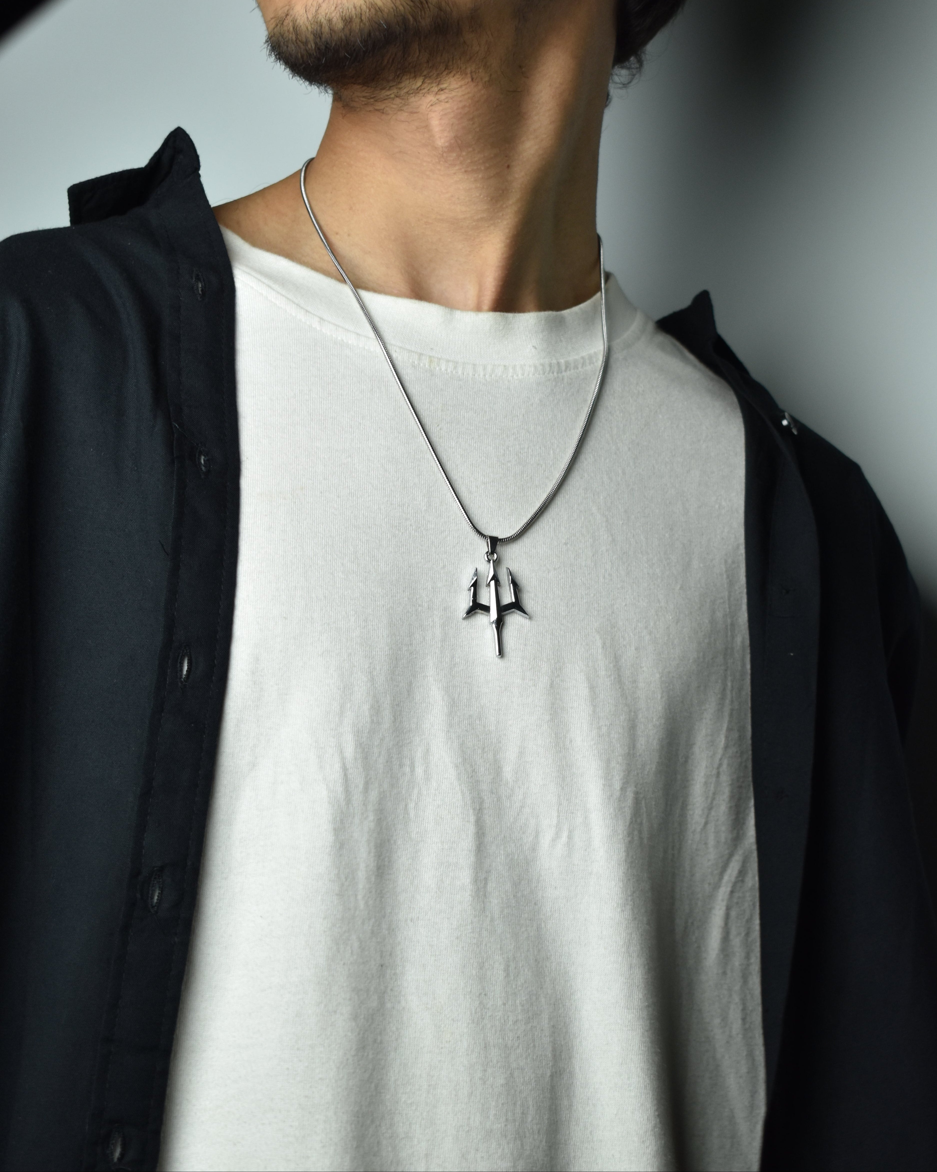 Person wearing a Trident Pendant  a plain background