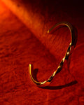 Gold bracelet on a red textured fabric background