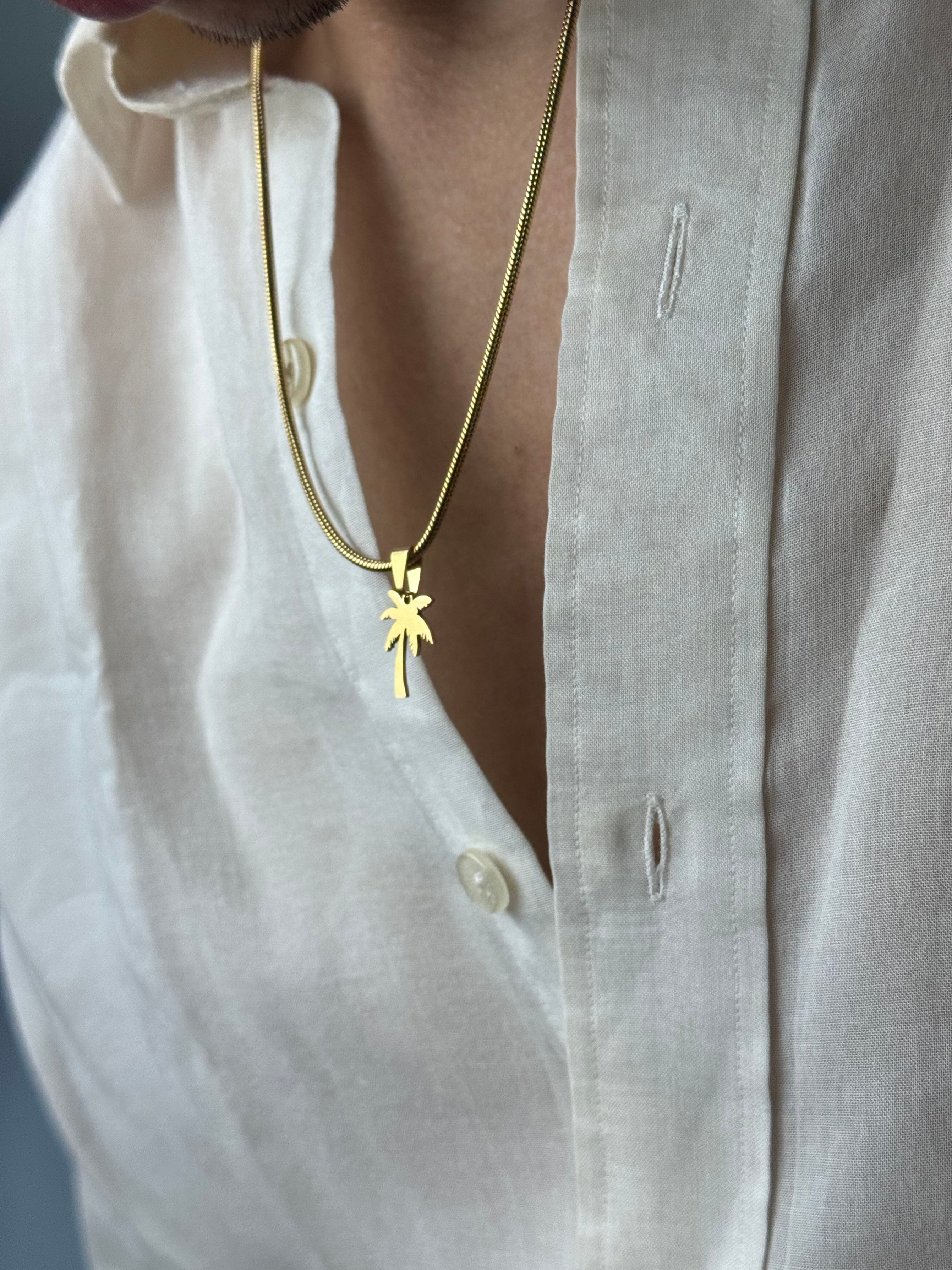 Gold necklace with a star pendant on a white shirt background