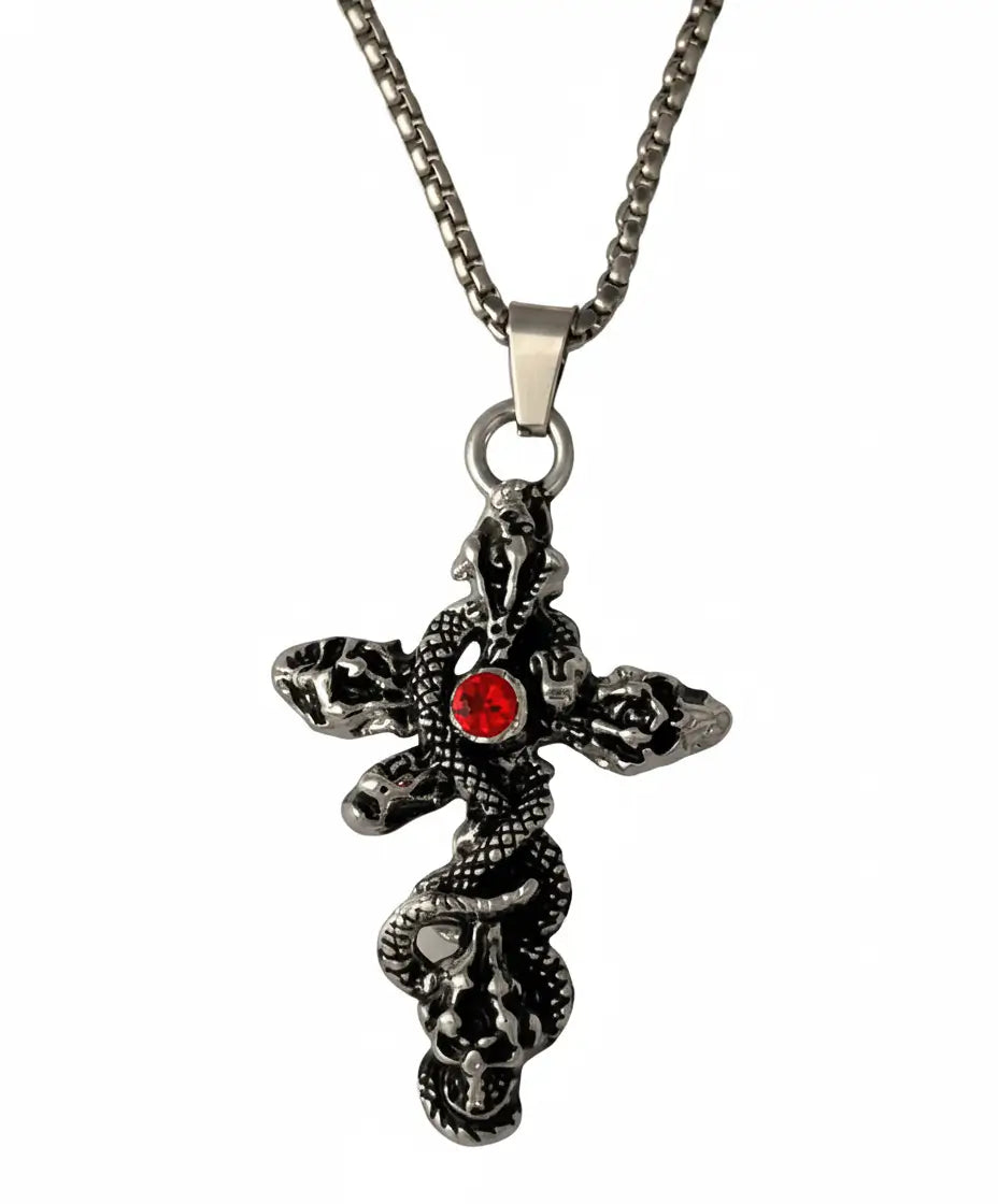 A gothic-style cross pendant necklace featuring a coiled snake design and a central red gemstone, suspended from a silver-toned chain against a plain white background.